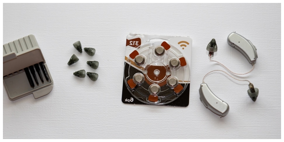 Hearing aids and hearing aid accessories laid out on the table