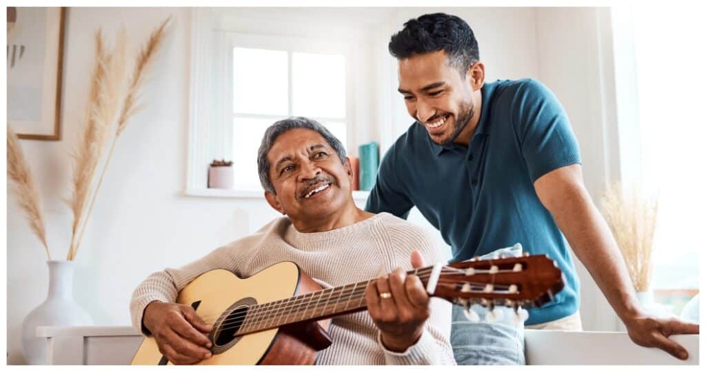 Father playing a guitar and son smling
